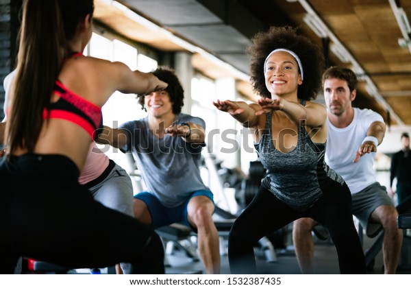 Diversity group of people training in a gym.\
Trainer and sportive persons\
exercising