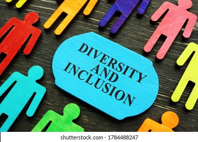 Diversity and inclusion phrase and colored wooden figurines.