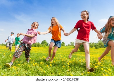 Diversity Looking Kids, Boys And Girls Running In The Yellow Flowers Spring Field