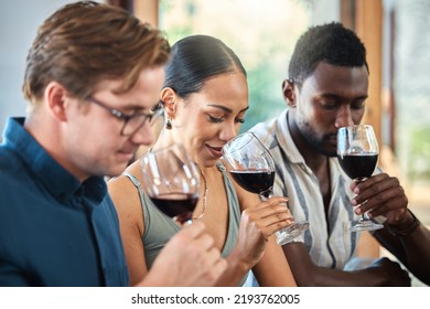 Diversity, luxury and friends wine tasting at a restaurant or vineyard, smelling alcohol in a glass together. Young carefree people bonding and having fun, enjoying a wine tour at a distillery - Powered by Shutterstock