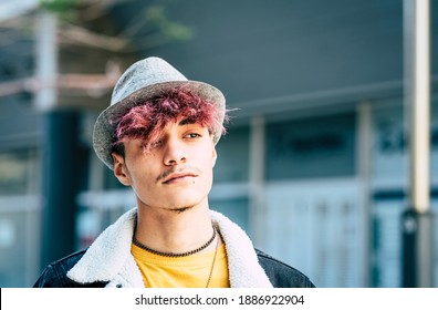 Diversity people portrait young teenager hispanic race with violet hair and hat - teen male looking with city defocused background