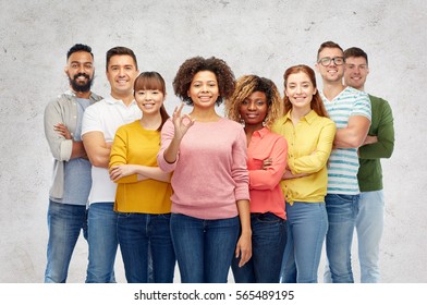 diversity, race, ethnicity and people concept - international group of happy smiling men and women showing ok hand sign over gray background - Shutterstock ID 565489195