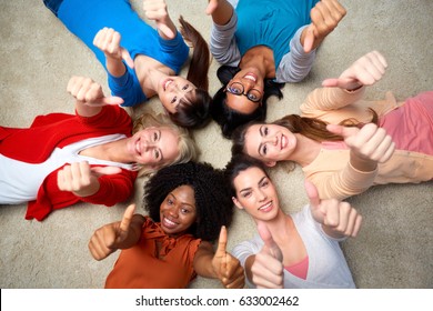 Diversity, Race, Ethnicity And People Concept - International Group Of Happy Smiling Different Women Lying On Floor In Circle And Showing Thumbs Up