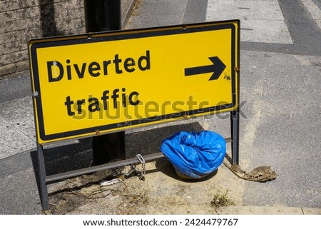 Diverted traffic sign with directional arrow showing reroute. Inconvenience for motorists on road 