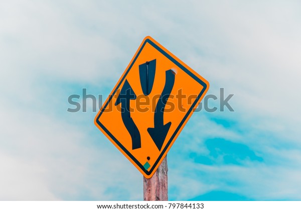 Divided\
road begins highway sign with blue sky\
background