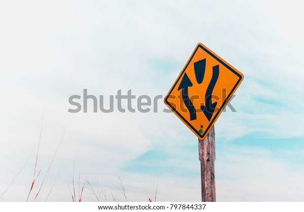 Divided\
road begins highway sign with blue sky\
background