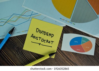 Dividend Aristocrat Write On Sticky Notes Isolated On Wooden Table.