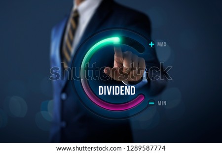 Dividend growth or increase dividend concept. Businessman is pulling up circle progress bar with the word DIVIDEND on dark tone background.