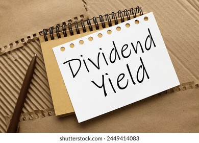 DIVIDEND YIELD craft notebook on a craft background. text on white page