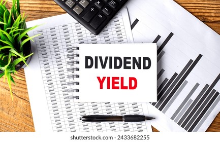 DIVIDEND YIELD text on notebook with chart and calculator