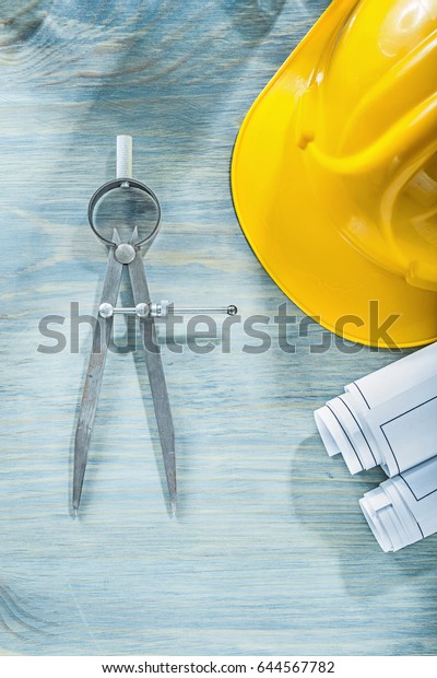 Divider engineering drawings hard hat on wooden\
board construction\
concept.
