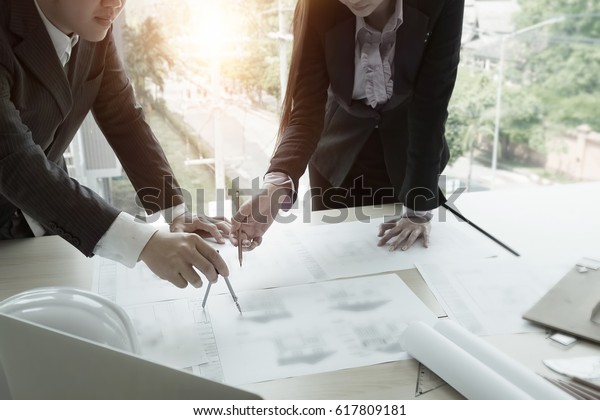 Dividers and pencil on hand Team Architect working\
on blueprint.engineer inspective in workplace - architectural\
project,Construction concept. Engineering tools on desk with\
vintage tone.