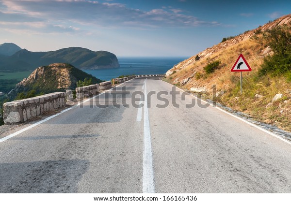 Dividing line and right turn sign on the\
coastal mountain highway.\
Montenegro