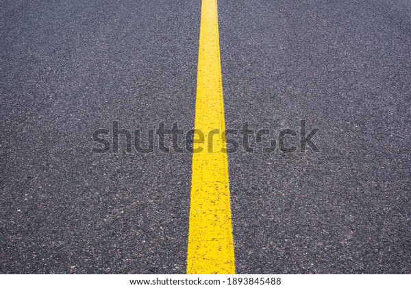 The dividing strip is\
yellow. Smooth asphalt surface with a yellow stripe. Road signs and\
symbols.