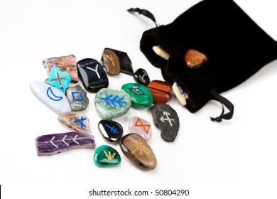 Divination Stones Called Witches Runes, Scattering Out Of Black Velvet Bag, Isolated On White.