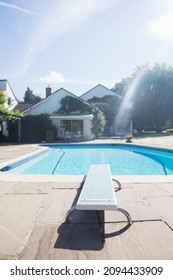 Diving Board At Edge Of Swimming Pool