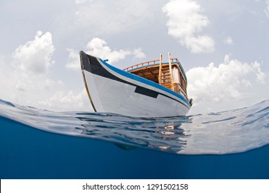 Diving Boat Of The Maldives From Beneath The Water Line In Tropical Sea