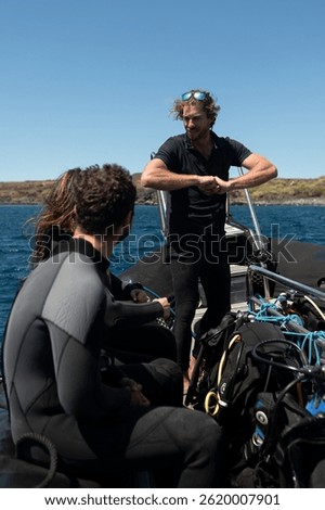 Diving instructor giving safety instructions to scuba divers on a boat before diving into the ocean