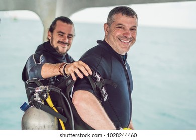 Diving Instructor Helps A Beginner Diver Prepare For Diving.