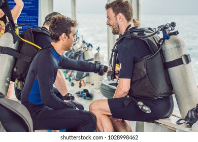 Diving Instructor Helps A Beginner Diver Prepare For Diving.