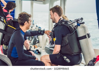 Diving Instructor Helps A Beginner Diver Prepare For Diving.