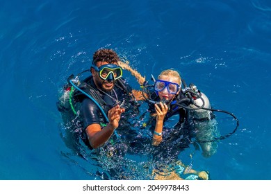 Diving Instructor Teaches Children To Scuba Dive Underwater. Discover Scuba Diving, Kids. Happy Family - Father, Son And Daughter In A Mask. Red Sea Egypt August 30, 2021