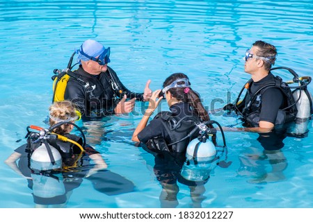 A diving instructor teaches a group of people to dive