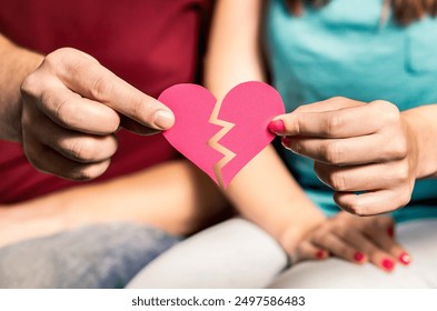 Divorce, breakup or separation. Ripped paper heart in hands of a couple. Finding match and love. Cheating, infidelity, betrayal, or trust problems in relationship. Split up woman and man. - Powered by Shutterstock