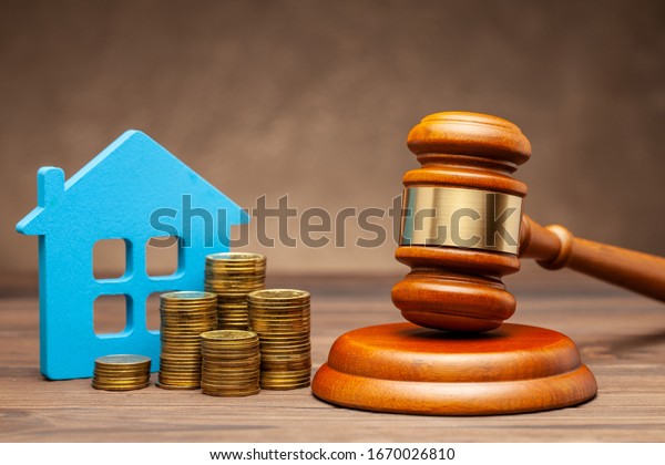 Divorce by law. Division of property after\
a divorce. House with money and a judge\
gavel.