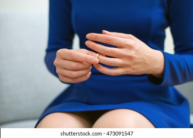 Divorce Concept. Woman Taking Off Wedding Ring.