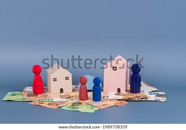 Divorce, conflict between
parents, children custody, property division. Wooden houses,
miniature figures of parents and children, cash money on gray
background