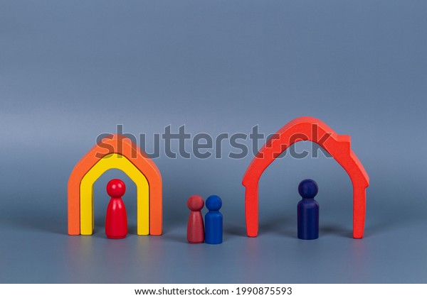 Divorce, conflict between parents, children\
custody, property division. Wooden houses, miniature figures of\
parents and children on gray\
background