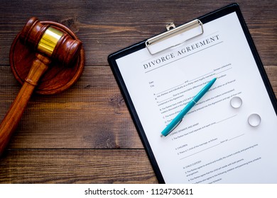 Divorce Court Case. Divorce Agreement Near Wedding Rings And Judge Gavel On Dark Wooden Background Top View Copy Space