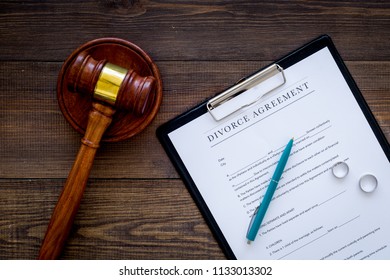 Divorce Court Case. Divorce Agreement Near Wedding Rings And Judge Gavel On Dark Wooden Background Top View