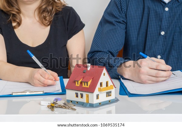 Divorce and dividing a property concept. Man\
and woman are signing divorce\
agreement.
