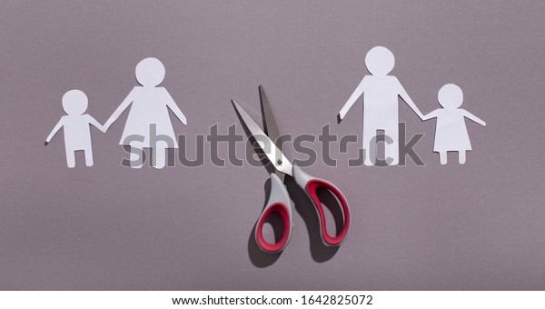 Divorce or family problems\
concept. Paper family cut out chain and scissors on gray\
background, panorama