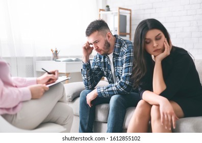 Divorce. Stressed Couple Sitting Separately At Family Counselor Office, Empty Space