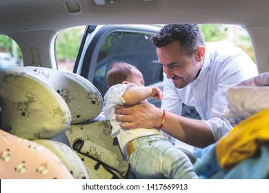 Divorced Father Taking his Baby from the Baby Seat . Separated Father Hanging Out with His Baby. Single Father Securing his Baby in the Car . Family Concept.