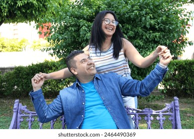 Divorced single dad spends time with his teenage brunette latin daughter in the park happily celebrating Father's Day
