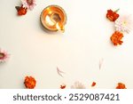 Diwali celebration. Diya lamp and beautiful flowers on light textured surface, flat lay. Space for text