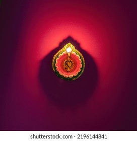 Diwali, Deepavali celebration, Hindu Festival of lights celebration. Diya oil lamp lit on red background, top view. 