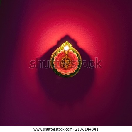 Diwali, Deepavali celebration, Hindu Festival of lights celebration. Diya oil lamp lit on red background, top view. 
