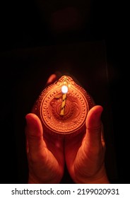 Diwali, Deepavali Hindu Festival Of Lights Celebration. Diya Oil Lamp Lit In Woman Hands, Dark Background. Top View. 
