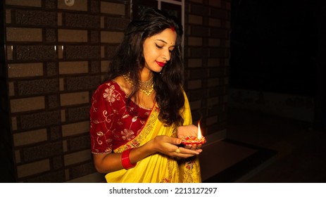 Diwali, Deepavali Hindu Festival Of Lights Celebration. Diya Or Oil Lamp In Woman Hands With Dark Background. Portrait Of Pretty Indian Women Wearing Traditional Saree, Jewellery.