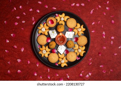 Diwali Diya On Red Background, Sweets OR Mithai In Indian Thali  Arranged Over Decorative Background. Selective Focus, Indian Festival