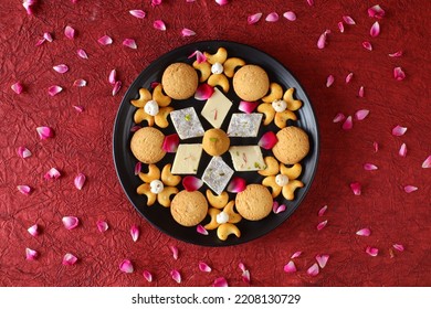 Diwali Diya On Red Background, Sweets OR Mithai In Indian Thali  Arranged Over Decorative Background. Selective Focus, Indian Festival