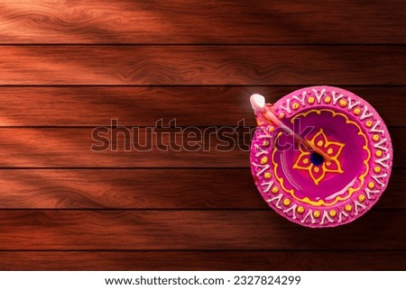 Diwali diya on wooden background with copy space