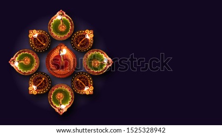 Diwali, Hindu festival of lights celebration. Clay diya colorful illuminated in Dipavali, Traditional oil lamps on dark background, top view, copy space
