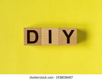 DIY Acronym, Inscription On Wooden Cubes On Yellow Background. Do It Yourself Concept.