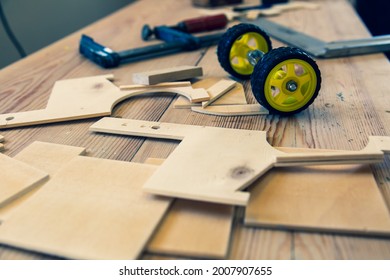 Diy Child Toy Car On A Wooden Work Bench In Carpentry Shop With Wrench And A Ruler On The Table